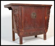 An early 20th century Chinese hardwood altar cabinet raised on block legs having a brass lock and