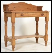 A 19th century Victorian pine gallery top washstand raised on turned and block legs with shelf to