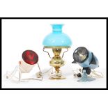 A collection of vintage 20th Century lamps to include an enamel projector, retro heat lamp and a