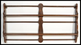 A vintage early 20th Century mahogany wall mounted plate rack in the manner of Ercol. Measures 57 cm