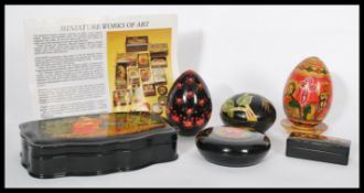 A collection of 20th Century Russian hand painted miniature papier mache and turned wooden