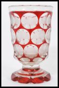 A 19th century Bohemian glass goblet vase raised on scalloped base with carved intaglios having
