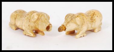 A pair of 19th century carved bone perfumer bottles modelled as pigs with cork stoppers to mouth.