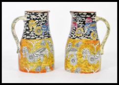 A pair of 19th century Mason's jugs having a Chinoserie decoration with yellow and black ground
