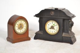 A Victorian slate large 8 day mantel clock with carved masks to the sides, decorative dial