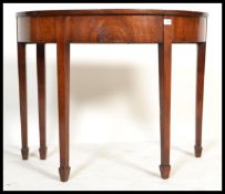 A 19th century George III mahogany demi - lune console table being raised on squared tapering legs