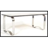 A 20th century modernists coffee table being supported by strapwork chrome base with black