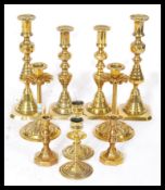 Five pairs of brass taper/ candlesticks dating from the 19th century to include Georgian pusher