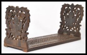 A 19th century Indian anglo colonial carved wooden metamorphic bookslide trough stand having pierced
