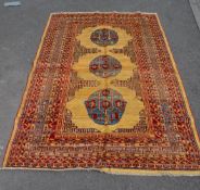 A 20th century red ground carpet floor rug including large yellow medallions. The Persian Islamic