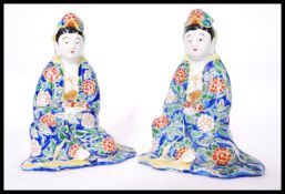 A pair of Chinese Republic period porcelain figures each holding a scroll having hand enamelled