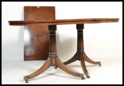 A 19th century Regency mahogany pedestal dining table being raised on reeded splayed legs with brass