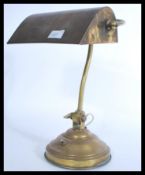 A vintage mid century brass bankers lamp raised on