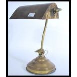 A vintage mid century brass bankers lamp raised on