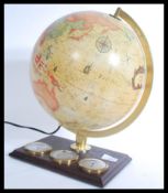 A vintage 20th century desk top globe raised on a