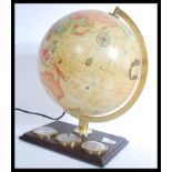 A vintage 20th century desk top globe raised on a