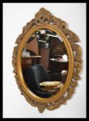 A vintage gilt surround oval wall mirror having an