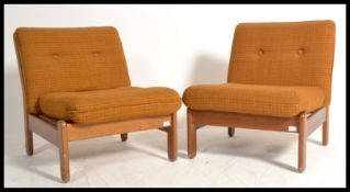 A pair of vintage mid century teak wood armchairs
