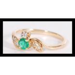 An 18ct yellow gold emerald and diamond ring havin