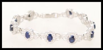 A silver Cubic Zirconia and sapphire paneled brace