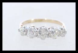 An 18 carat gold ring with 5 round diamonds in dec