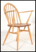 A mid century Ercol beech and elm carver armchair
