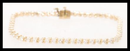 A 14 carat yellow gold diamond tennis bracelet wit