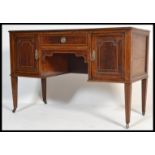 An  Edwardian inlaid mahogany kneehole writing table desk raised on tapering legs with brass castors