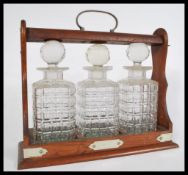 A 19th century Victorian oak triple decanter Tantalus having silver plated mounts. Complete with