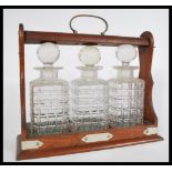 A 19th century Victorian oak triple decanter Tantalus having silver plated mounts. Complete with