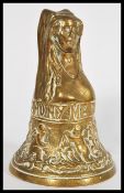 An early 20th century brass bell in the form of a maiden in a head dress, having a floral design