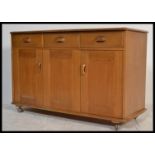 A 20th century blond sideboard by Priory furniture in the manner of Ercol with a configuration of