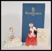 A pair of Doulton ladies figurines to include Day Dream HN1731 and Christmas Morn HN1992 with its