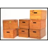 A collection of seven pine lidded storage boxes with carry handles to the side, removable lids.