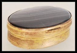 An Agate box of oval form with two pieces of stone set into embossed brass and a small fan opening