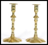 A pair of Georgian early 18th century brass candle stick holders with splat floral bases and