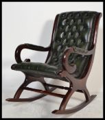A 20th Century slipper rocking chair / armchair upholstered in green buttoned leather, mahogany