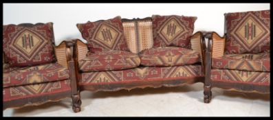 An early 20th century walnut and upholstered three piece bergere suite, consisting of matching