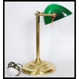 A vintage retro 20th century gilt brass bankers lamp raised on a circular base with reeded column