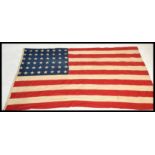 A vintage retro 1940's large American stars and stripes flag having riveted corners. Measures 130 cm