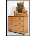 An Edwardian Arts & Crafts pine dressing table raised on a plinth base with short and deep drawers