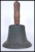 A 19th Century Bronze hand bell with turned wooden handle and cast iron clapper. Measures: 30cm