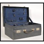 A vintage early 20th century navy blue leather 1920's suitcase having a fitted watered silk fabric