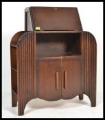 A vintage 20th century Art Deco wooden writing bureau having twin cupboards with fold down writing