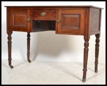 An early 20th century Edwardian mahogany knee hole writing table desk raised on turned legs with