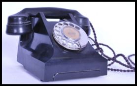 A mid 20th century retro vintage black bake lite phone with a ring dial, please see images for