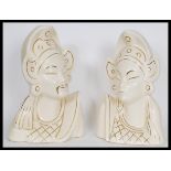 A pair of Asiatic white ceramic bust figures depicting a man and a woman in traditional dress with