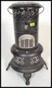 A vintage early 20th century Valor stove having a pierced design with black painted finish. Measures