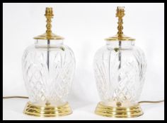 A pair of  matching Waterford Crystal lead cut glass table lamps raised on brass pedestals with