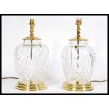 A pair of  matching Waterford Crystal lead cut glass table lamps raised on brass pedestals with